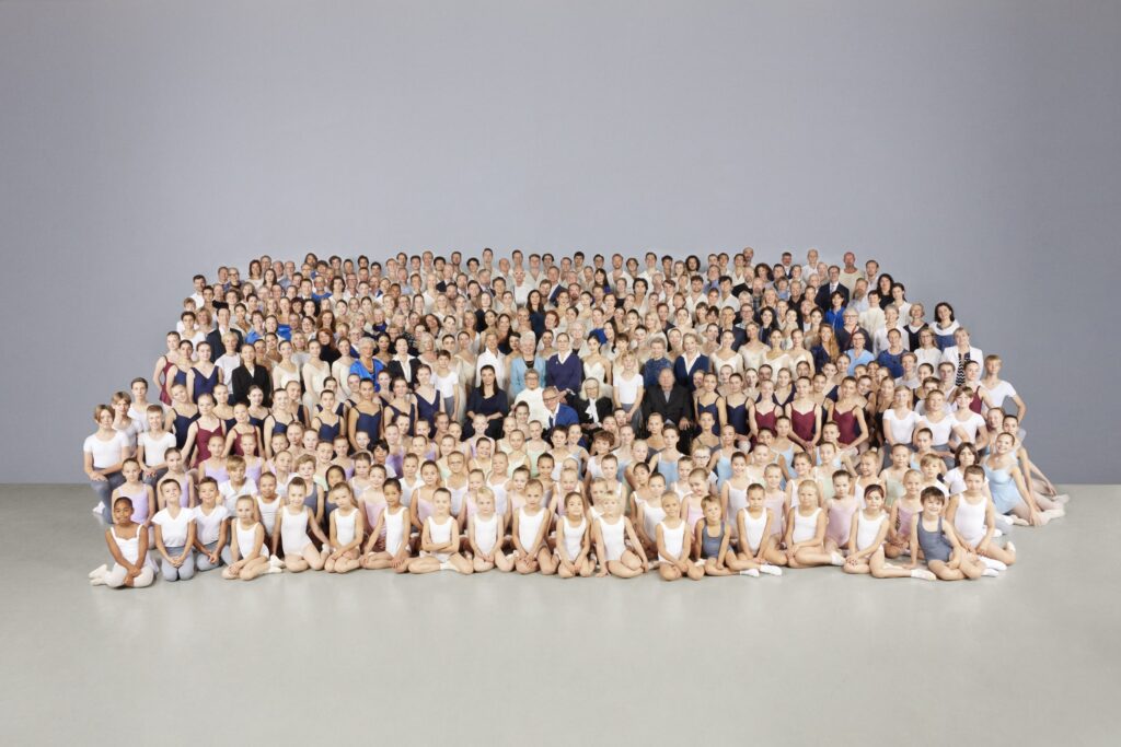 Kansallisbaletin entisiä ja nykyisiä tanssijoita sekä Balettioppilaitoksen oppilaita ryhmäkuvassa.